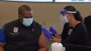 Critical care nurse Tony Chris Nnaka gets the COVID-19 vaccine at Parkland Memorial Hospital in Dallas, Dec. 15, 2020.