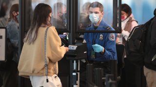 A Transportation Security Administration (TSA) agent screens an airline passenger at O’Hare International Airport on October 19, 2020 in Chicago, Illinois.