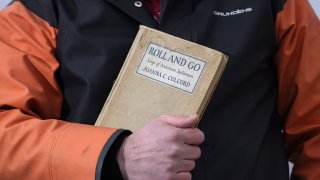 Bennett Konesni holds a book of sea shanties Thursday, Jan. 28, 2021, in Belfast, Maine. Work songs have helped sailors on long ocean journeys to break up the tedium. The genre is seeing a global revival among people bored and isolated by the coronavirus pandemic.