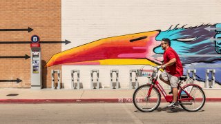 Man riding bike past Magnolia Station