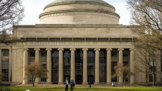 People stand on the lawn outside Building 10 on the Massachusetts Institute of Technology (MIT) campus in Cambridge, Massachusetts, U.S., on Monday, April 20, 2020.