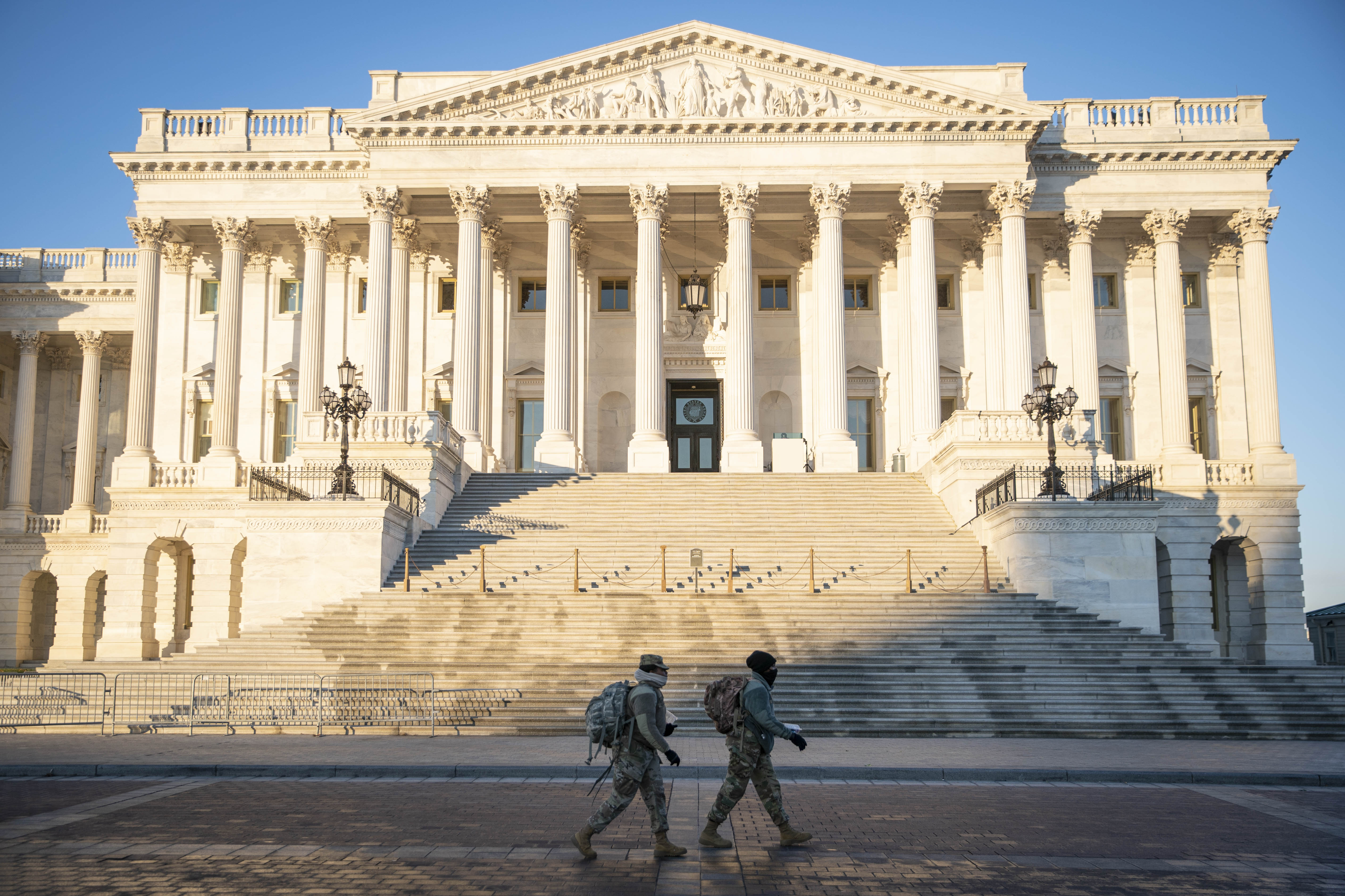 Members of the National Guard walk past the Senate side of the U.S. Capitol building in Washington, D.C., U.S., on Tuesday, Jan. 12, 2021. House Speaker Pelosi has instructed members of the House to return to Washington to consider a second impeachment of President Donald Trump this week. Photographer: Sarah Silbiger/Bloomberg via Getty Images