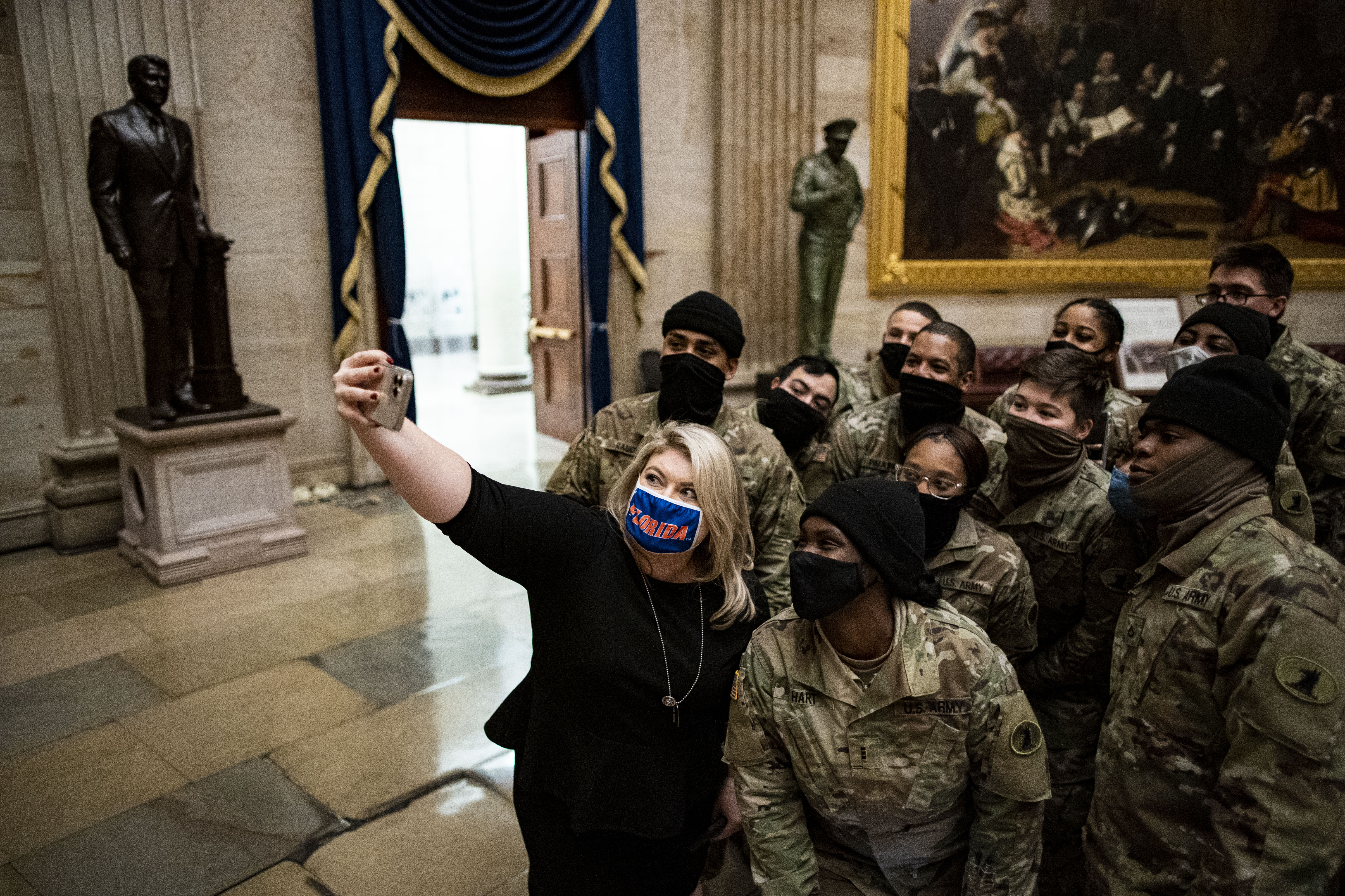 Representative Kat Cammack, a Republican from Florida, takes a selfie photograph with members of the National Guard in the Rotunda at the U.S. Capitol in Washington, D.C., U.S., on Wednesday, Jan. 13, 2021. President Donald Trump suffered an unprecedented public rebuke on Wednesday when the House of Representatives impeached him for a second time, clouding his prospects for a potential return to politics just days before he leaves the White House. Photographer: Al Drago/Bloomberg via Getty Images