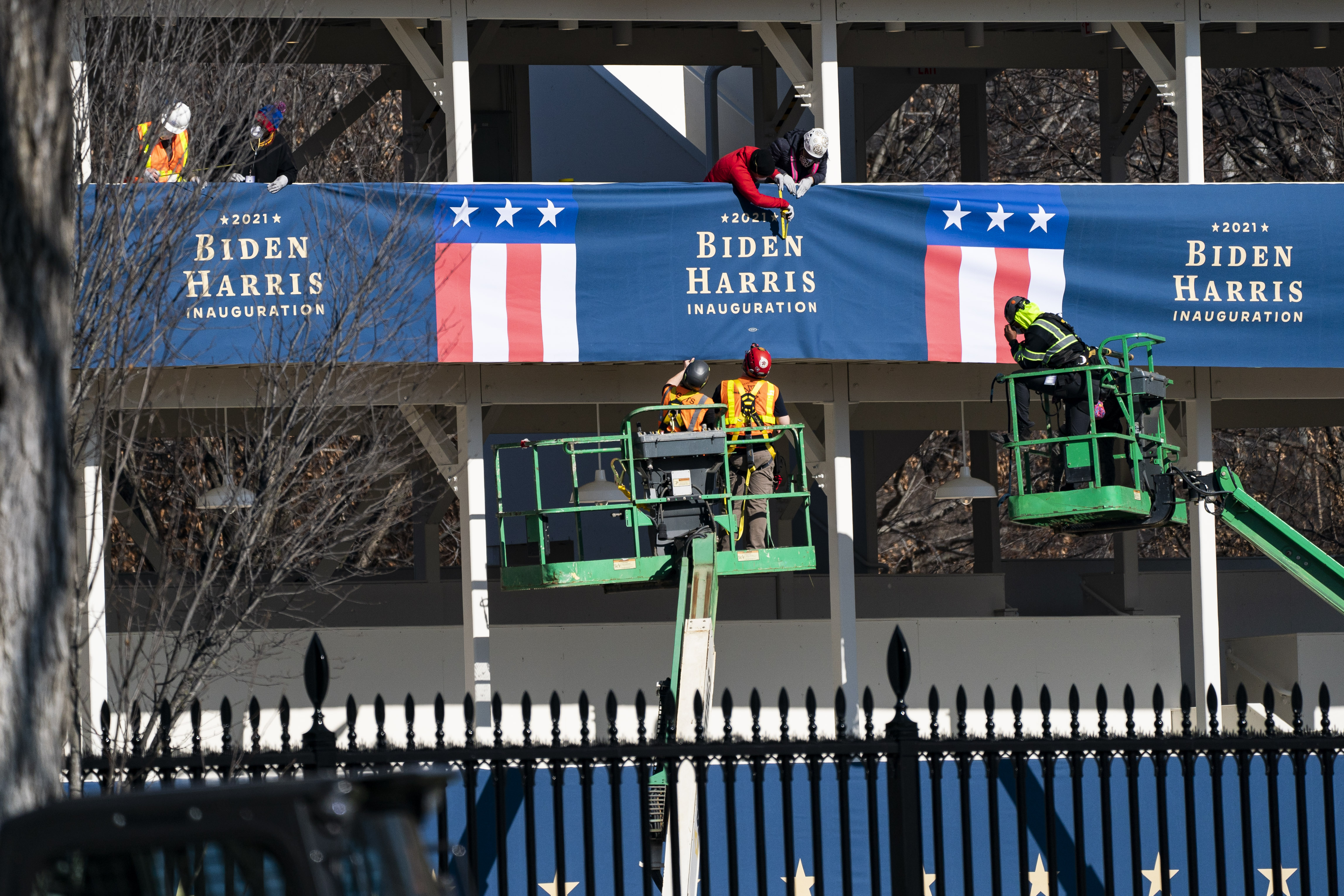 WASHINGTON, DC &#8211; JANUARY 14: Workers hang banners for President-Elect Biden and Vice President-Elect Kamala Harris ahead of the inauguration on a press riser just outside the north gate at the White House on Thursday, Jan 14, 2021 in Washington, DC. (Photo by Jabin Botsford/The Washington Post via Getty Images)