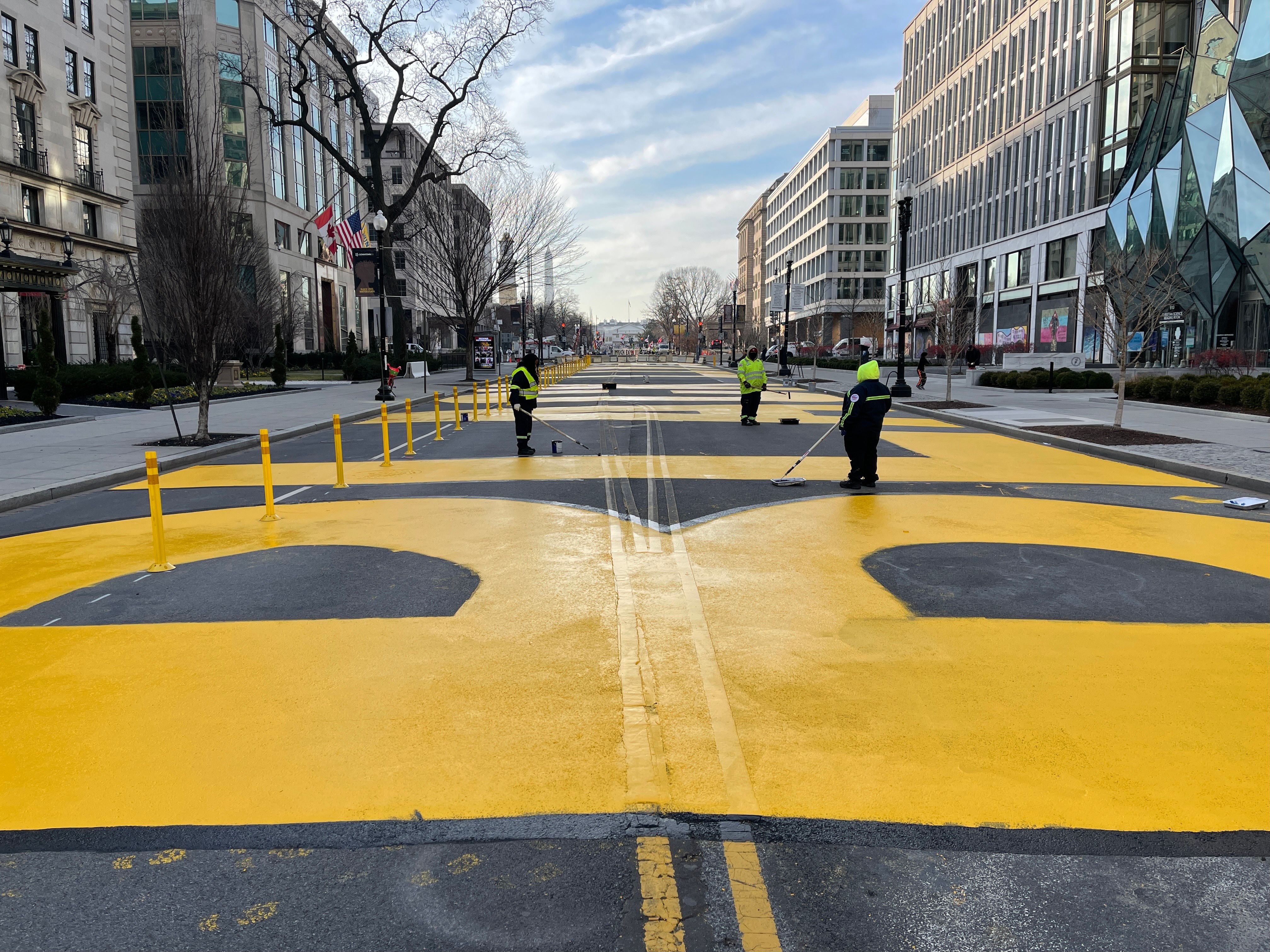 Workers repaint the BLM letters at Black Lives Matter Plaza in Washington, DC, on January 15, 2021. (Photo by Daniel SLIM / AFP)