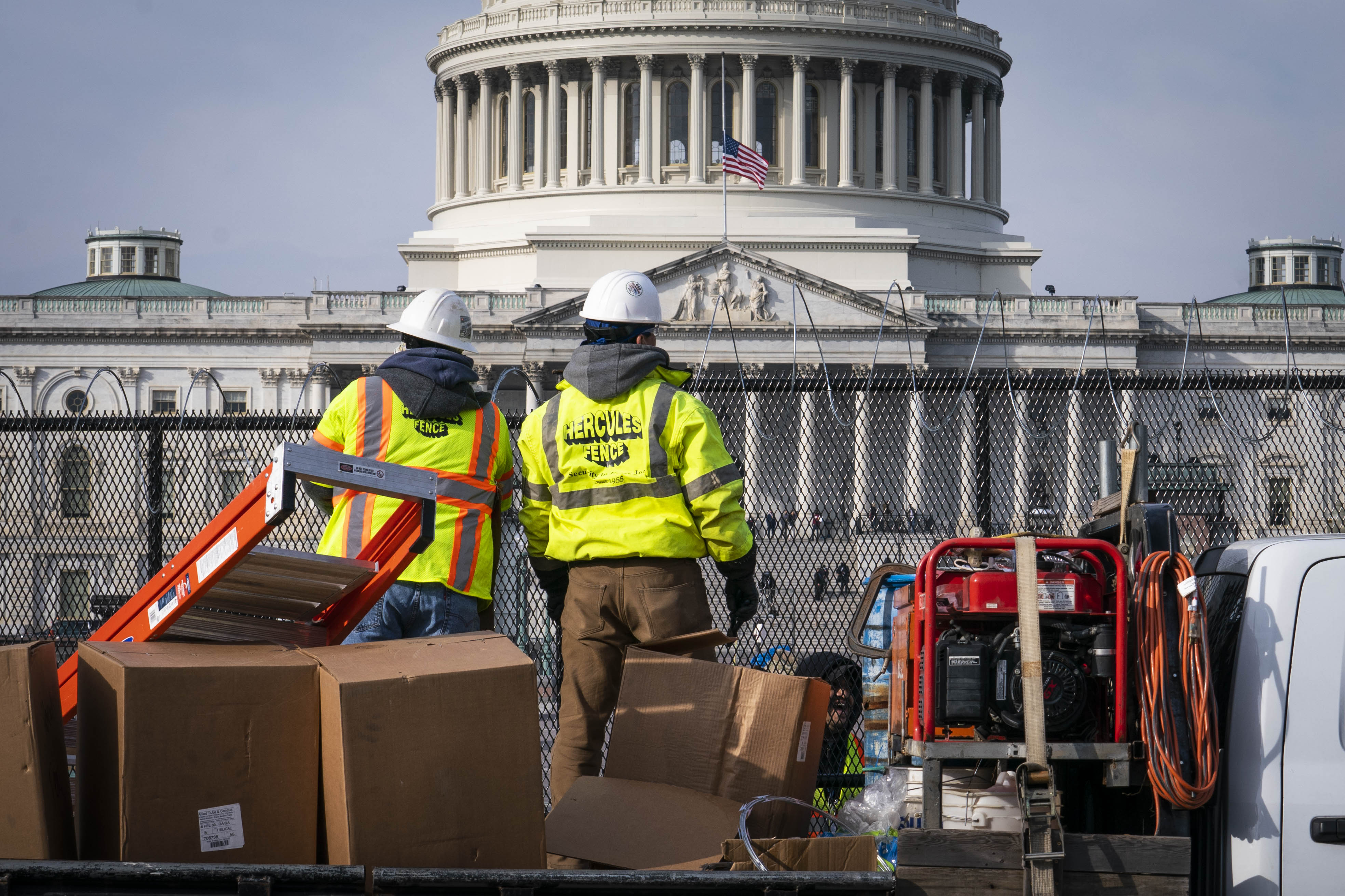 Workers install barbed wire on the fenced perimeter of the U.S. Capitol in Washington, D.C., U.S., on Friday, Jan. 15, 2021. The timing for both President Trump&#8217;s impeachment trial and legislation to provide Americans with more Covid relief now largely depends on maneuvering by three of the most veteran legislative tacticians in Congress. Photographer: Sarah Silbiger/Bloomberg via Getty Images