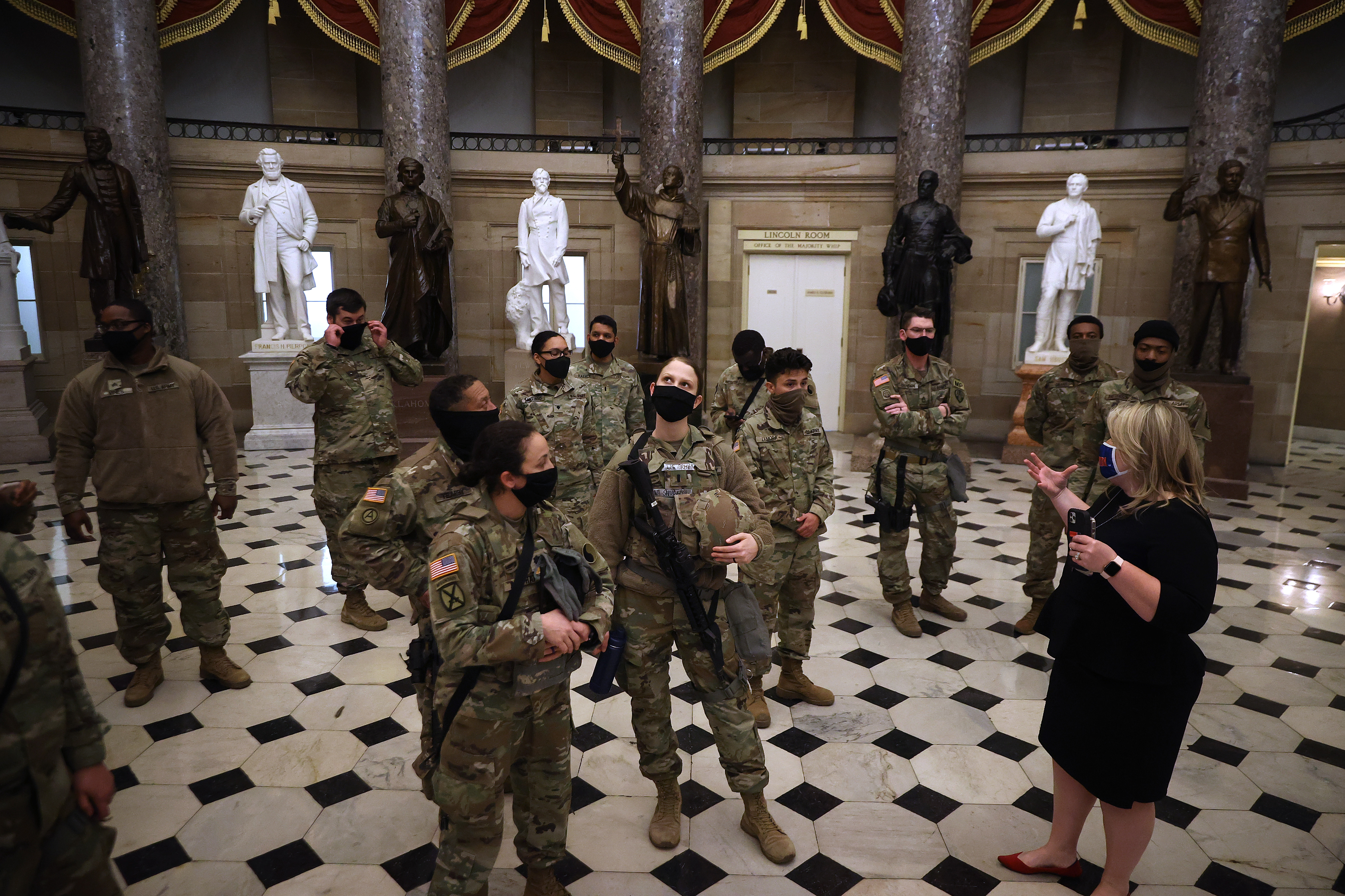 WASHINGTON, DC &#8211; JANUARY 13:  Exactly one week after a violent mob stormed through the U.S. Capitol, members of the Virginia National Guard are given a tour Statuary Hall by Rep. Kat Cammack (R-FL) minutes after the House voted to impeach U.S. President Donald Trump for the second time in little over a year in the House Chamber of the U.S. Capitol January 13, 2021 in Washington, DC. The House voted 232-197 to impeach Trump on the charge of “incitement of insurrection&#8221; after a mob attacked the U.S. Capitol where Congress was working to certify the Electoral College victory of President-elect Joe Biden on January 6. 10 Republicans voted to impeach. (Photo by Chip Somodevilla/Getty Images)