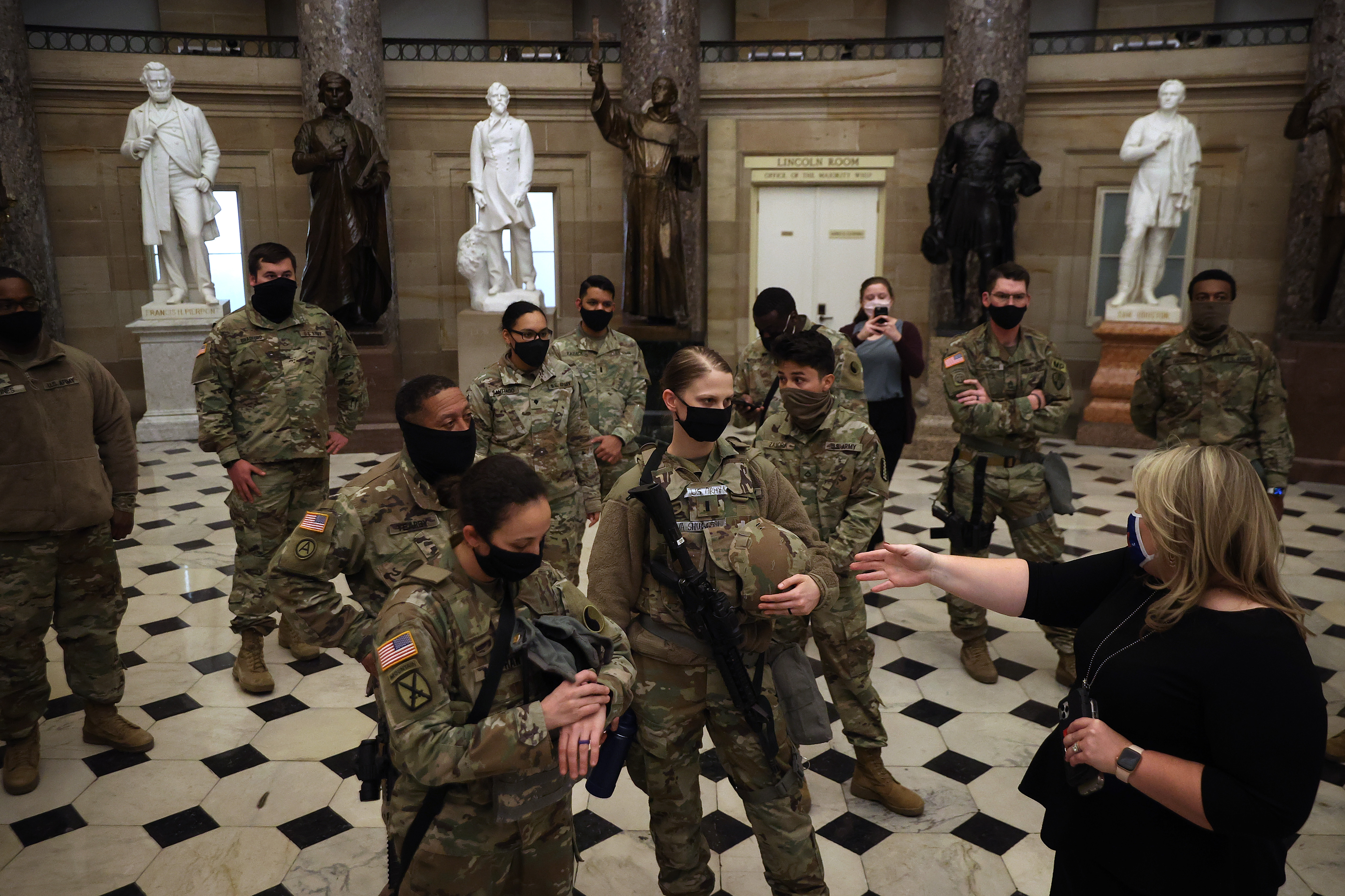 WASHINGTON, DC &#8211; JANUARY 13:  Exactly one week after a violent mob stormed through the U.S. Capitol, members of the Virginia National Guard are given a tour Statuary Hall by Rep. Kat Cammack (R-FL) minutes after the House voted to impeach U.S. President Donald Trump for the second time in little over a year in the House Chamber of the U.S. Capitol January 13, 2021 in Washington, DC. The House voted 232-197 to impeach Trump on the charge of “incitement of insurrection&#8221; after a mob attacked the U.S. Capitol where Congress was working to certify the Electoral College victory of President-elect Joe Biden on January 6. 10 Republicans voted to impeach. (Photo by Chip Somodevilla/Getty Images)