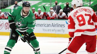 Jason Dickinson #18 of the Dallas Stars skates the puck against Vladislav Namestnikov #92 of the Detroit Red Wings in overtime at American Airlines Center on Jan. 26, 2021 in Dallas, Texas.