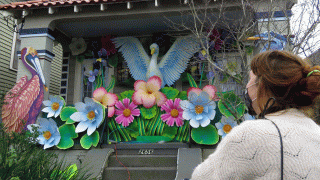 In this Jan. 8, 2021, file photo, parade float workers Travis Keene, left, and Joey Mercer position a pelican while fellow crew member Chelsea Kamm, right, looks on while decorating a house in New Orleans.
