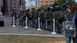 More than 100 Texas troopers, including dozens wearing tactical vests and carrying riot gear, stood on guard outside the state Capitol on Tuesday as lawmakers returned to work amid FBI warnings of armed protests at statehouses across the country.