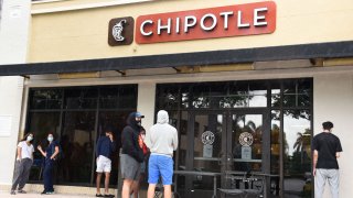 In this May 19, 2020, file photo, customers wait outside of a Chipotle restaurant as they wait to enter in order to place an order as Florida continues with its Phase 1 of reopening the state during the Coronavirus (COVID-19) pandemic in Aventura, Florida.