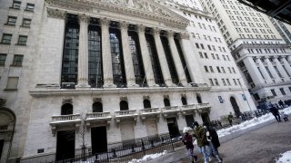 People walk past the New York Stock Exchange (NYSE) amid the coronavirus disease (COVID-19) pandemic in New York, February 3, 2021.