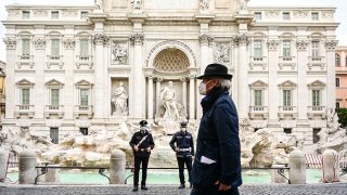 A man in front of the desolate Trevi fountain in Rome, Italy.