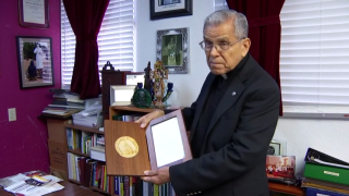 Father Jasso holding up an award