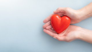 American Heart Month- Hands holding Heart