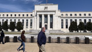 People walk past the Federal Reserve building on March 19, 2021 in Washington, DC.
