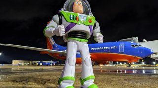 Buzz Lightyear toy in front of a Southwest plane