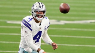 Dak Prescott in his cowboys uniform on the field preparing to receive a football