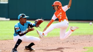 SOUTH WILLIAMSPORT, PENNSYLVANIA - AUGUST 25: Alton Shorts #2 of the Southwest Region team from River Ridge Louisiana slides safely into second base in front of Curley Martha #12 of the Caribbean Region team from Willemstad, Curacao during the Championship Game of the Little League World Series at Lamade Stadium on August 25, 2019 in South Williamsport, Pennsylvania.