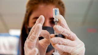 Healthcare worker holds up a vial of the covid vaccine