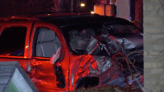 A damaged Chevy Tahoe after a car crash with the reflection of police lights