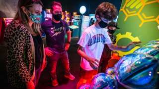 Group of kids playing at the guinness exhibition with bright colors illuminating their faces