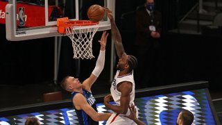 Kawhi Leonard #2 of the LA Clippers makes the slam dunk against Kristaps Porzingis #6 of the Dallas Mavericks in the fourth quarter at American Airlines Center on March 15, 2021 in Dallas, Texas.
