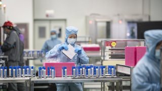 Employees manufacture photovoltaic cells on the production line at the Longi Green Energy Technology Co. plant in Xi’an, China, on July 21, 2020.