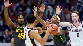 Jalen Suggs #1 of the Gonzaga Bulldogs looks to pass as Davion Mitchell #45 and Flo Thamba #0 of the Baylor Bears defend in the National Championship game of the 2021 NCAA Men's Basketball Tournament at Lucas Oil Stadium on April 5, 2021 in Indianapolis, Indiana.