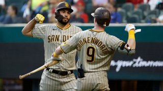 Eric Hosmer #30 of the San Diego Padres and Jake Cronenworth #9 of the San Diego Padres celebrate Hosmers solo home run against the Texas Rangers during the fourth inning at Globe Life Field on April 10, 2021 in Arlington, Texas.