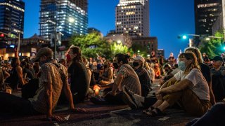 FILE: People sit in the street at a vigil for Garrett Foster on July 26, 2020 in downtown Austin, Texas. Garrett Foster, 28, who was armed and participating in a Black Lives Matter protest, was shot and killed after a chaotic altercation with a motorist who allegedly drove into the crowd. The suspect, who has yet to be identified, was taken into custody.