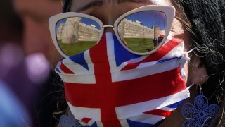 A woman looks towards Windsor Castle and St George's Chapel and waits to take part in a two minute silence during the funeral of Prince Philip