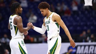 Davion Mitchell #45 and MaCio Teague #31 of the Baylor Bears clasp hands late in the game against the Arkansas Razorbacks in the Elite Eight round of the 2021 NCAA Division I Men's Basketball Tournament held at Lucas Oil Stadium on March 29, 2021 in Indianapolis, Indiana.