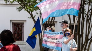In this file photo, protestors in support of transgender rights rally outside the Alabama State House in Montgomery, Ala., on Tuesday, March 30, 2021.