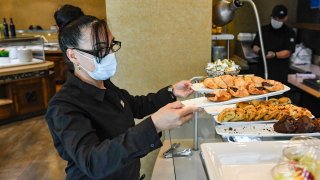 Server Nioka Mantilla arranges items in the buffet at the DoubleTree by Hilton Hotel on Penn Street in Reading, Pennsylvania, Friday morning May 7, 2021.
