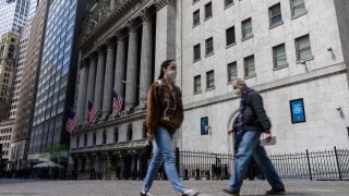 People walk past the New York Stock Exchange on Wall Street on May 10, 2021 in New York City.