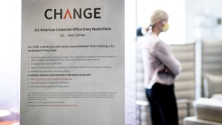 A sign details entry restrictions at a JLL office in the Aon Center in Chicago, Illinois, U.S., on Thursday, June 24, 2020.