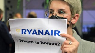A woman stands with a poster reading ‘Where is Roman (Protasevich)?!’ in the arrival area as passengers disembark from a Ryanair passenger plane from Athens, Greece, that was intercepted and diverted to Minsk on the same day by Belarus authorities, after it landed at Vilnius International Airport, its initial destination, on May 23, 2021.