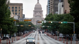 Cars drive on Congress Avenue in front of the Texas Capitol building on July, 14, 2020 in Austin, Texas. Only nine ICU beds were available Friday, July 30, in the 11-county trauma service region that includes Austin and serves 2.3 million people, according to the health department.