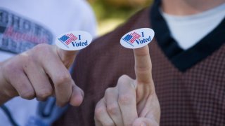 Young voters show the “I Voted” stickers after voting at a polling station in Plano, Texas, the United States, Nov. 3, 2020.