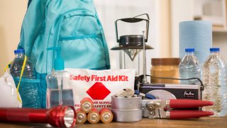 Emergency preparedness supplies. A large collection of supplies to be used in case of a natural disaster (hurricane, flood, earthquake, etc) including flashlight, backpack, batteries, water bottles, first aid kit, lantern, radio, can opener and mask. No People.