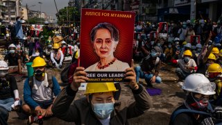 An anti-coup protester holds up a placard featuring de-facto leader Aung San Suu Kyi on March 02, 2021 in Yangon, Myanmar.