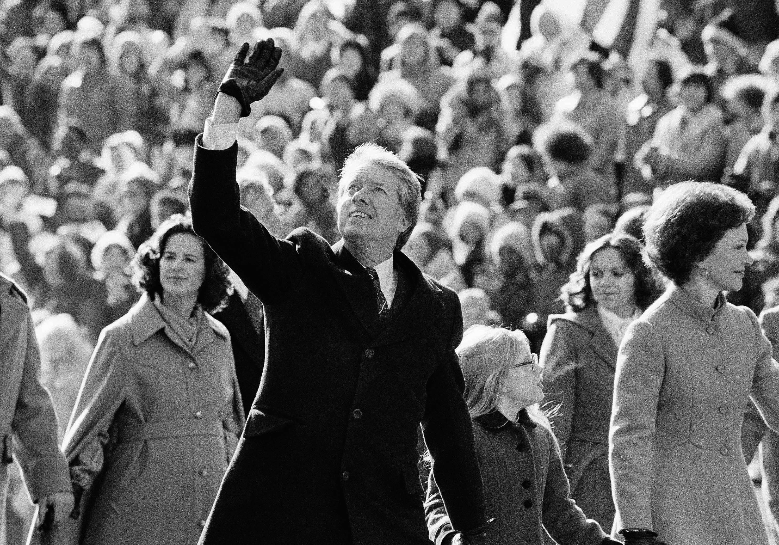 President Jimmy Carter waves to the crowd while walking with his wife, Rosalynn, and their daughter, Amy, along Pennsylvania Avenue from the Capitol to the White House following his inauguration in Washington, Jan. 20, 1977.