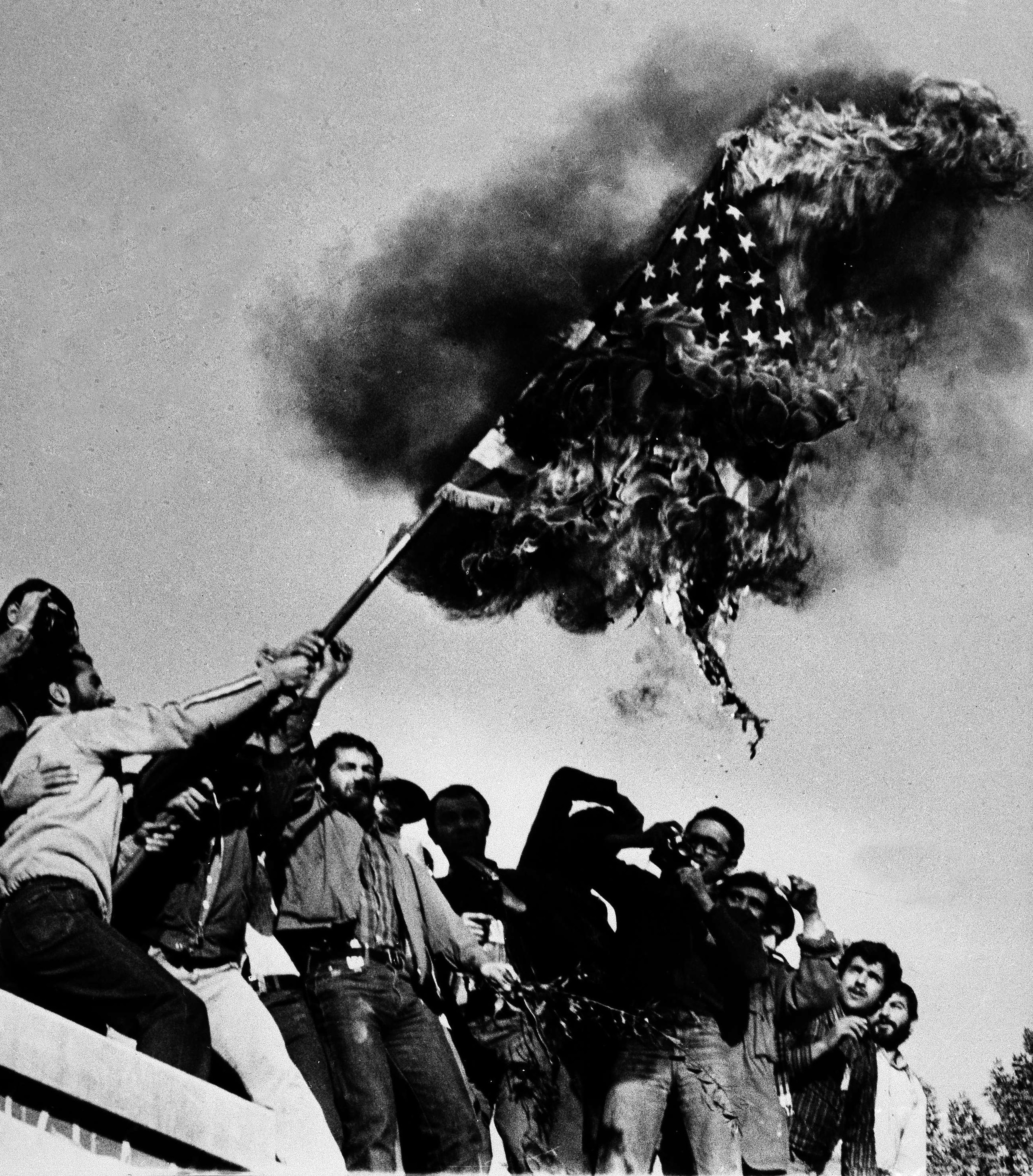 Demonstrators burn an American flag, Nov. 9, 1979, atop the wall of the U.S. Embassy where American hostages have been held since Nov. 4. The Iranian hostage crisis, which ended in failure for Carter, was one of the reasons why he lost his reelection bid to Ronald Reagan.