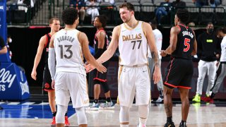 Jalen Brunson #13 of the Dallas Mavericks high fives Luka Doncic #77 of the Dallas Mavericks during the game against the Toronto Raptors on May 14, 2021 at the American Airlines Center in Dallas, Texas.