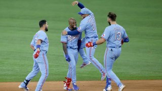 Adolis Garcia #53 of the Texas Rangers and teammates Jose Trevino #23, Isiah Kiner-Falefa #9 and Joey Gallo #13 celebrate Garcia's game winning walk-off RBI single against the Houston Astros at Globe Life Field on May 23, 2021 in Arlington, Texas. The Rangers won 3-2.