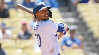 Mookie Betts #50 of the Los Angeles Dodgers hits a one run home run against Starting pitcher Dane Dunning #33 of the Texas Rangers during the third inning of their inter-league game at Dodger Stadium on June 13, 2021 in Los Angeles, California.