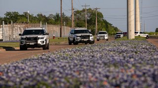 Bryan Police Department officers maintain a perimeter near the scene of a shooting at Kent Moore Cabinets on April 8, 2021 in Bryan, Texas. According to reports, a suspect is now in custody after one person was killed and five others were wounded in the shooting.