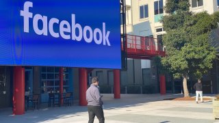 An employee of the Internet company Facebook walks through the courtyard of the company campus in Menlo Park, California.